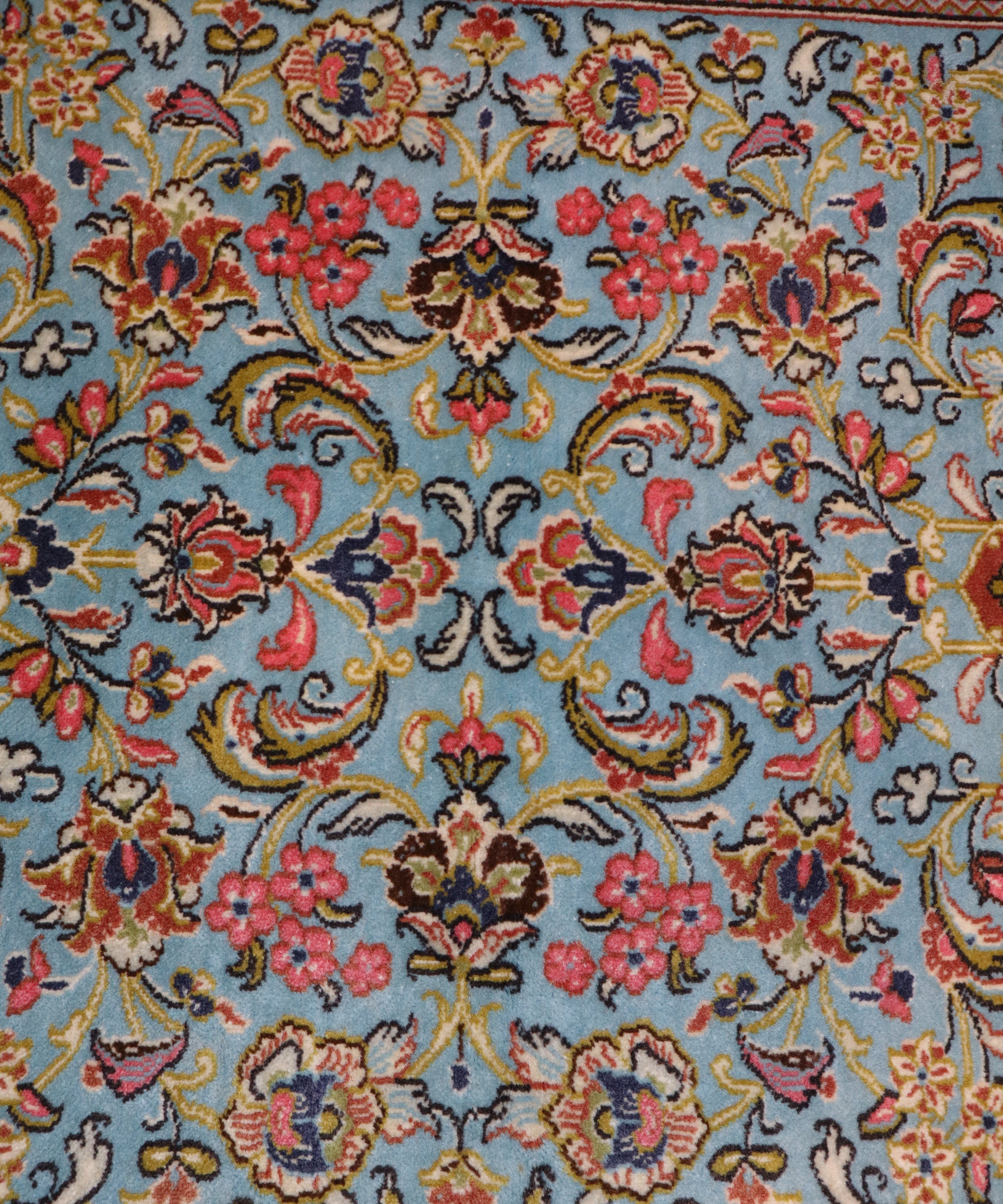 Floral textile detail on Persian wool runner rug in red, blue, yellow, and black