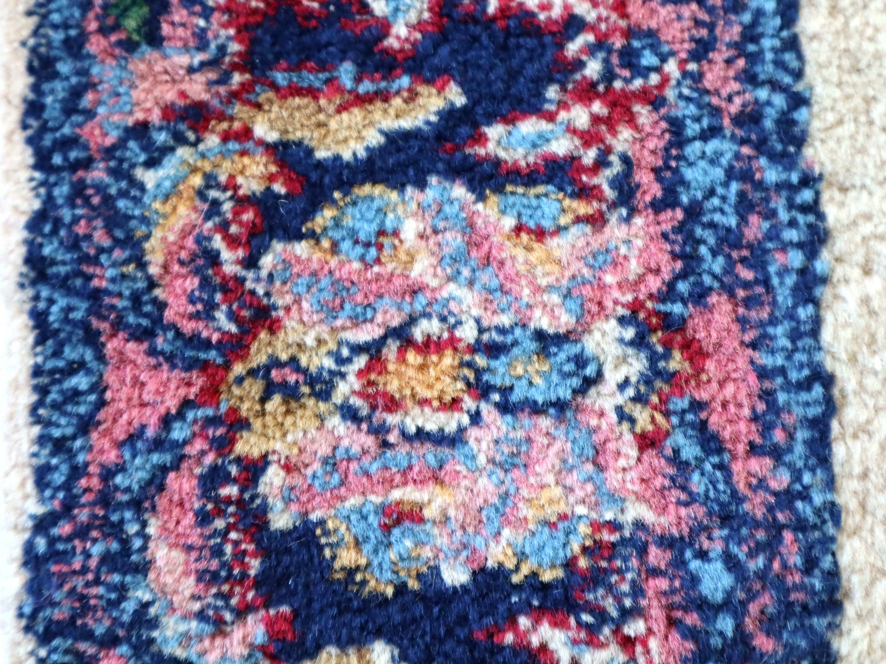 Close-up of multicolor floral medallion pattern in navy, red, and pink on off-white
