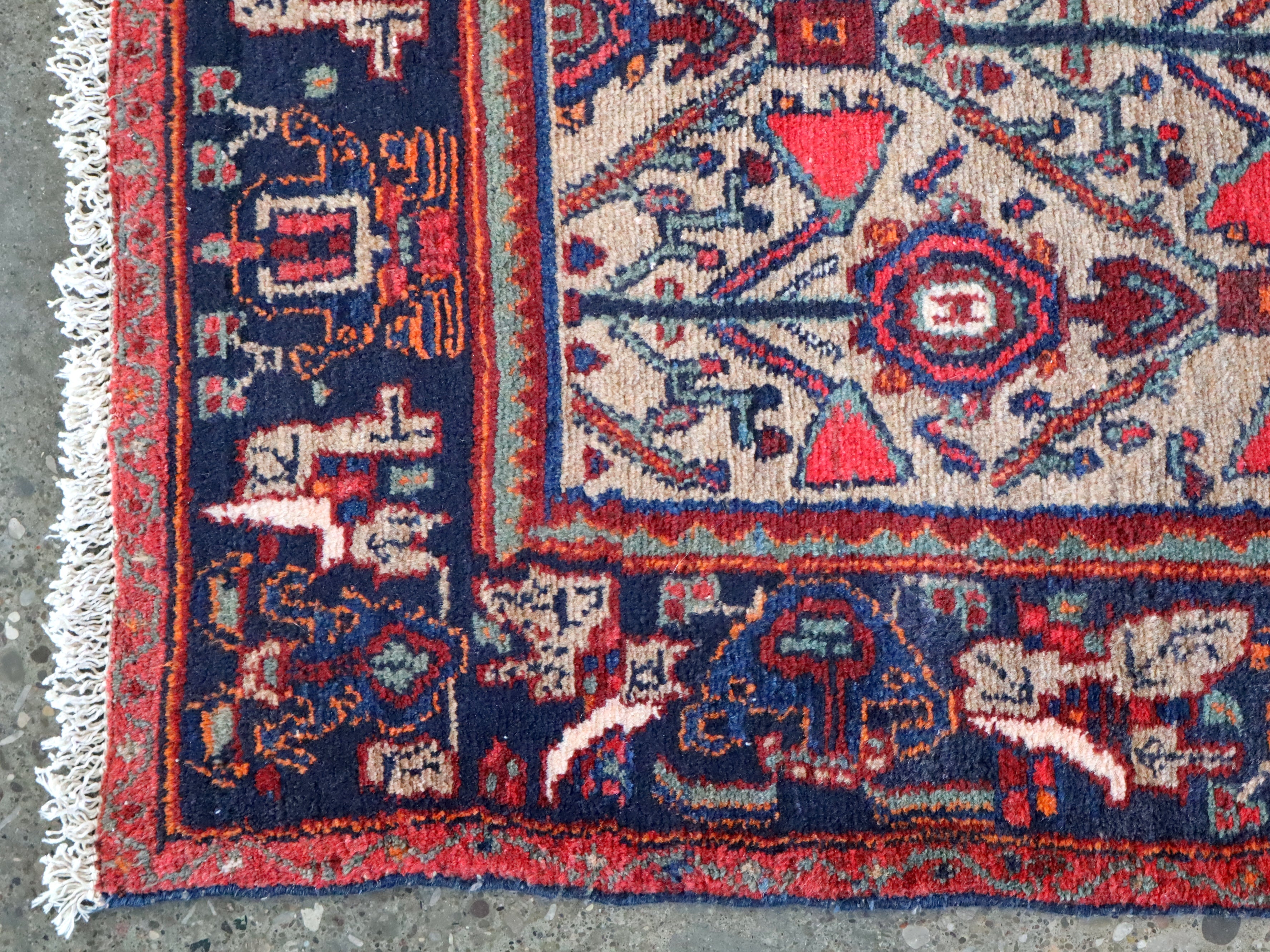 Rug border detail with dark blue and red geometric panels and cream accents along the edge