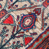Rug texture and pattern close-up with cream field, red triangles, and blue rosette centers