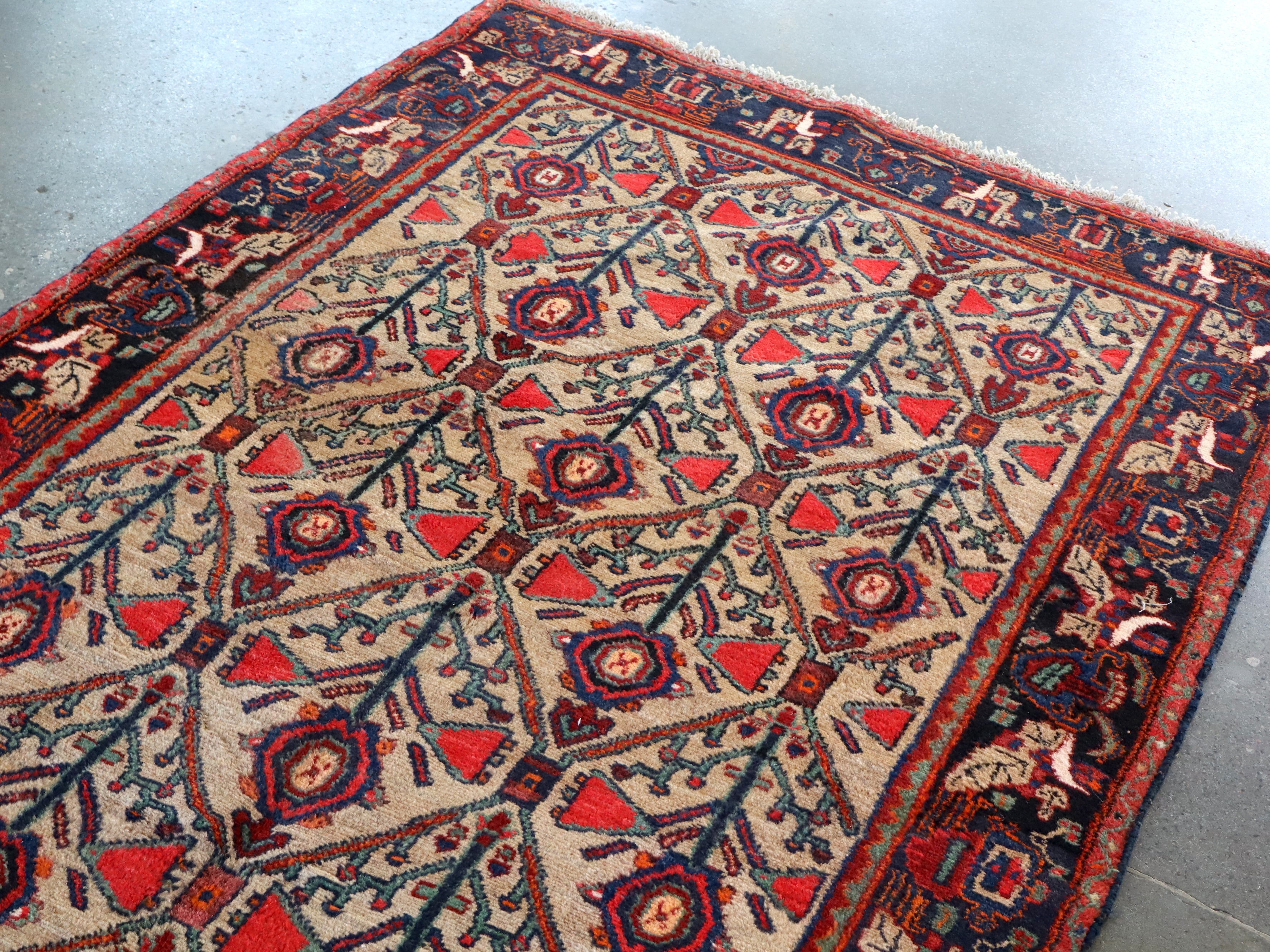 Area rug top view with central medallions in blue and red, light field, ornate dark border