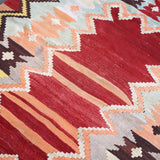 Turkish kilim rug close-up with red, cream, light blue and brown geometric bands