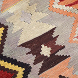 Turkish kilim rug close-up of cream, orange, and dark brown geometric shapes
