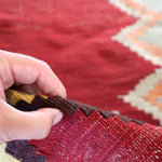 Turkish kilim rug texture close-up with red fabric and geometric weave pattern