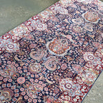 Fine Persian Kirman runner rug diagonal view with navy field and red medallion accents