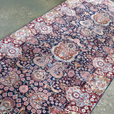 Fine Persian Kirman runner rug diagonal view with navy field and red medallion accents