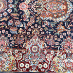 Fine Persian Kirman runner rug close-up of colorful floral border with navy accents