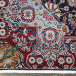 Fine Persian Kirman runner rug close-up of multicolor medallions on navy background