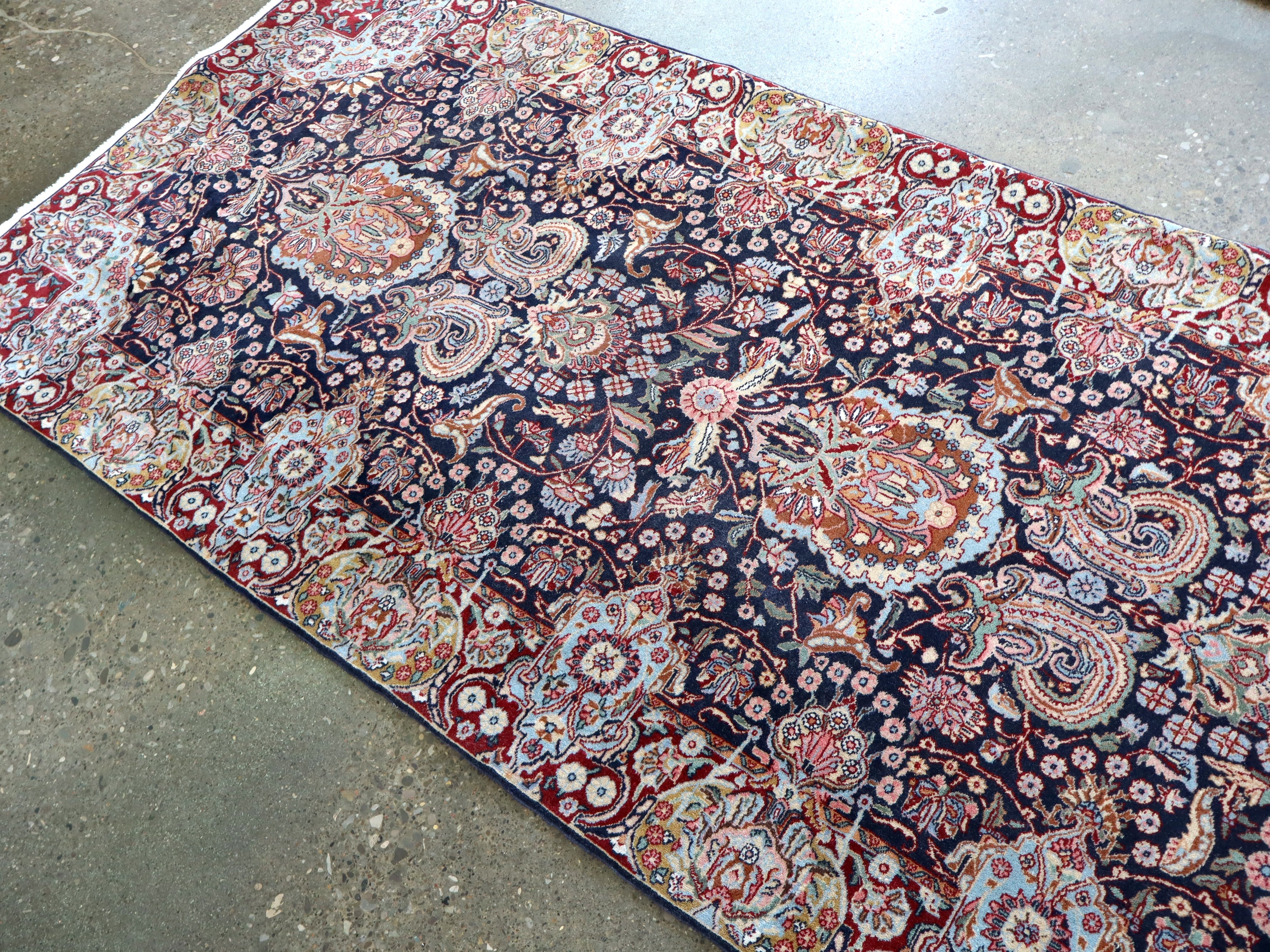 Ornate Persian-style runner rug, wide floral medallion design in navy, red, blue and cream