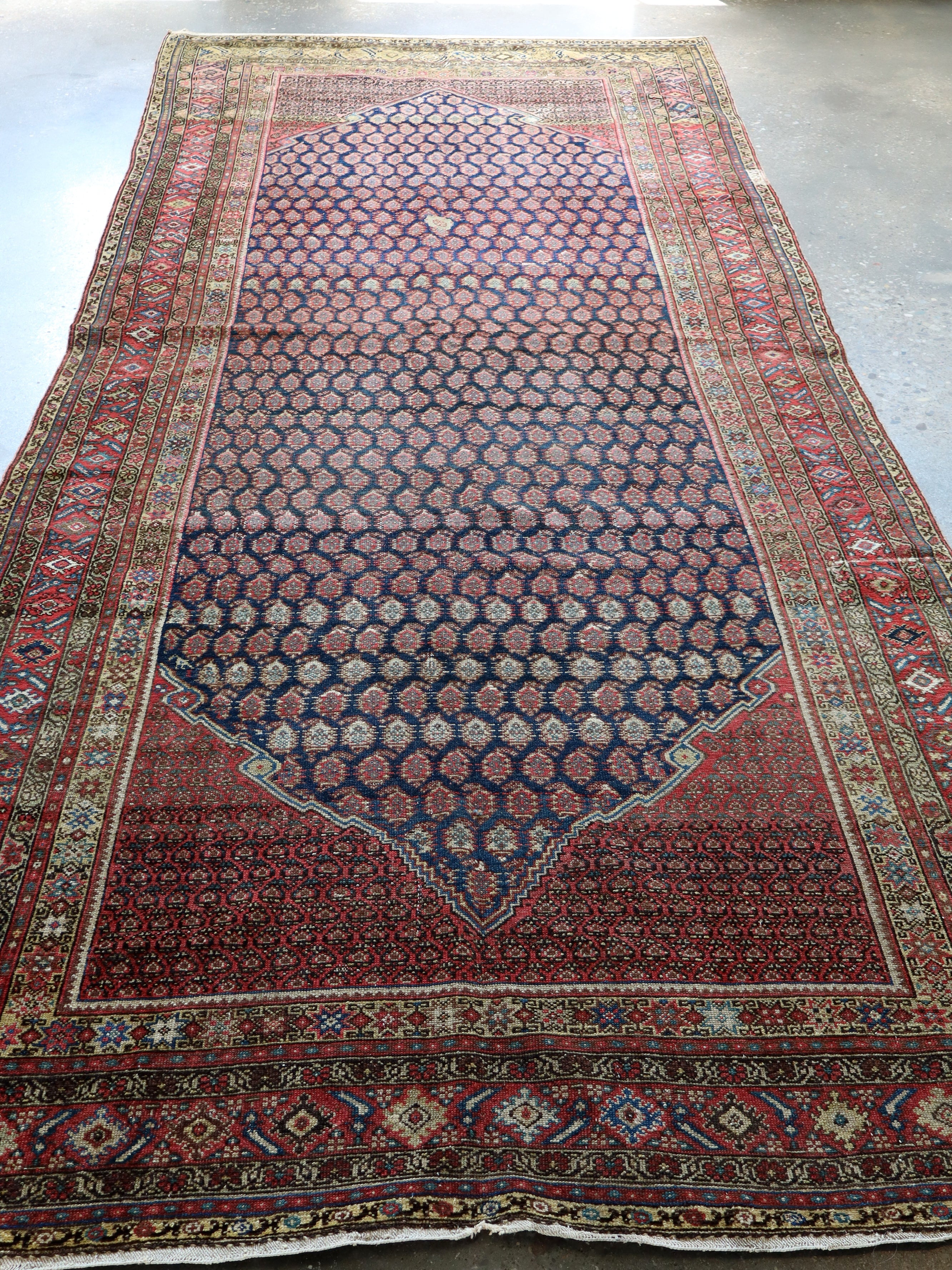 Persian Malayer rug with navy octagon center and red, cream, and teal borders