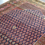 Close-up of Persian Malayer rug navy field with repeating lattice medallions