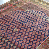 Close-up of Persian Malayer rug navy field with repeating lattice medallions