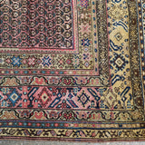 Persian Malayer rug corner border with red, blue, cream motifs and navy trim