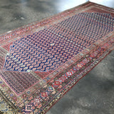 Persian Malayer rug flat view with navy center and red border with detailed trims