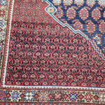 Malayer rug with dark red and blue geometric medallion border pattern