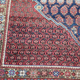 Malayer rug with dark red and blue geometric medallion border pattern