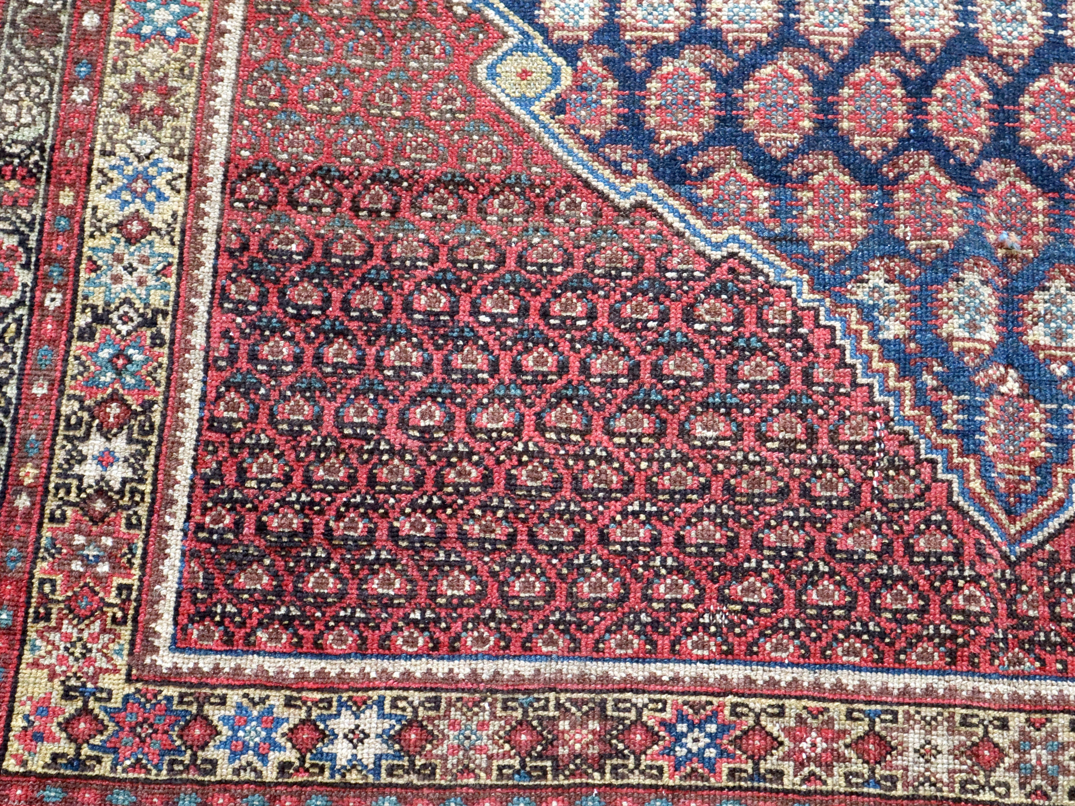 Malayer rug with dark red and blue geometric medallion border pattern
