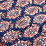 Malayer rug close-up of blue, red, and cream repeating diamond pattern