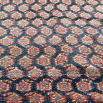 Malayer rug close-up of dense blue, red, and cream geometric pattern