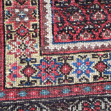 Malayer rug detail with red corner motifs, blue accents, and cream border