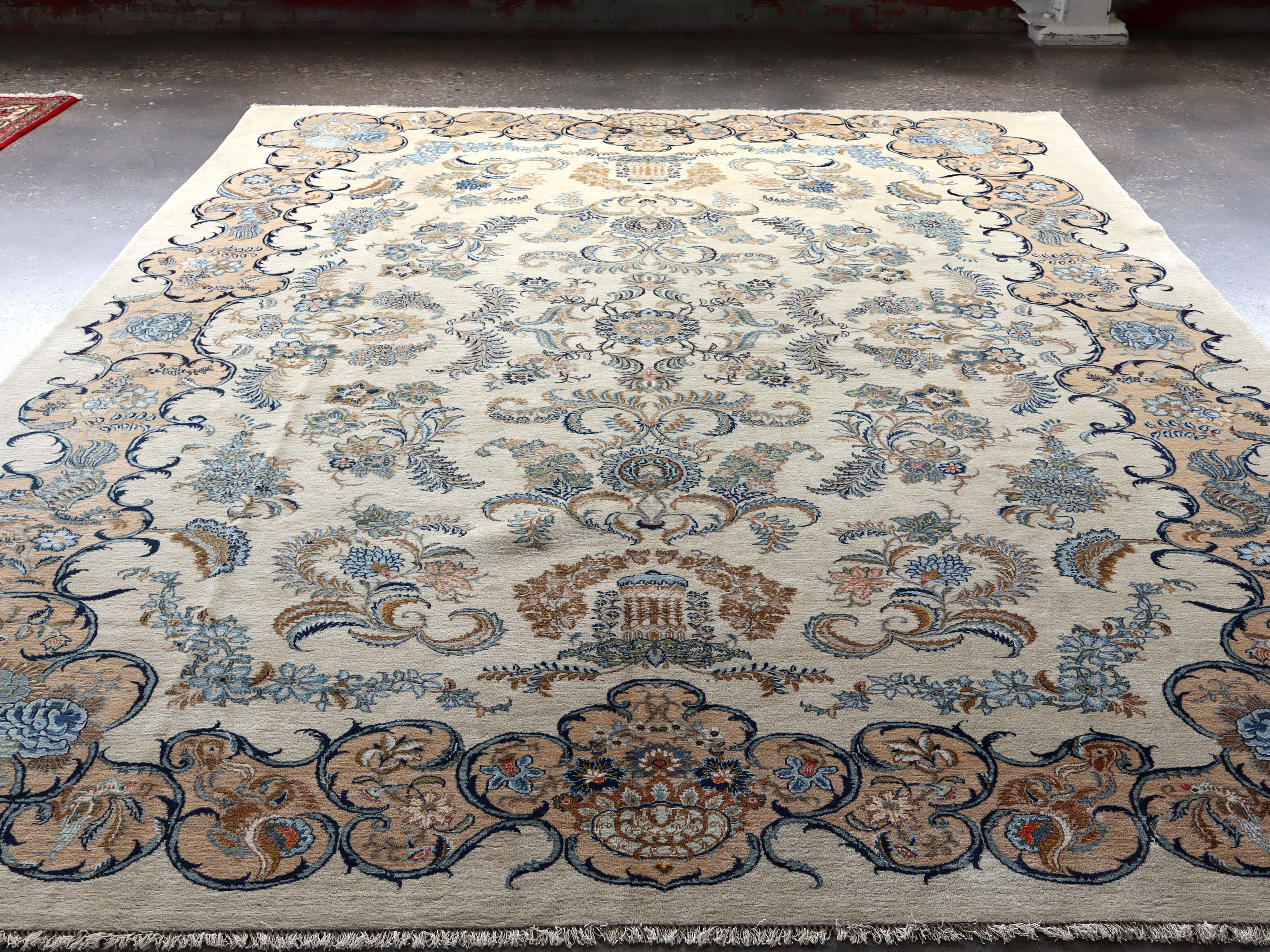Persian Kashan rug with ivory center and blue scrollwork border; central medallion