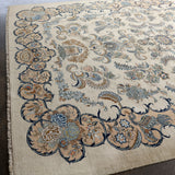 Persian Kashan rug with cream background and dark navy scroll border; floral cluster