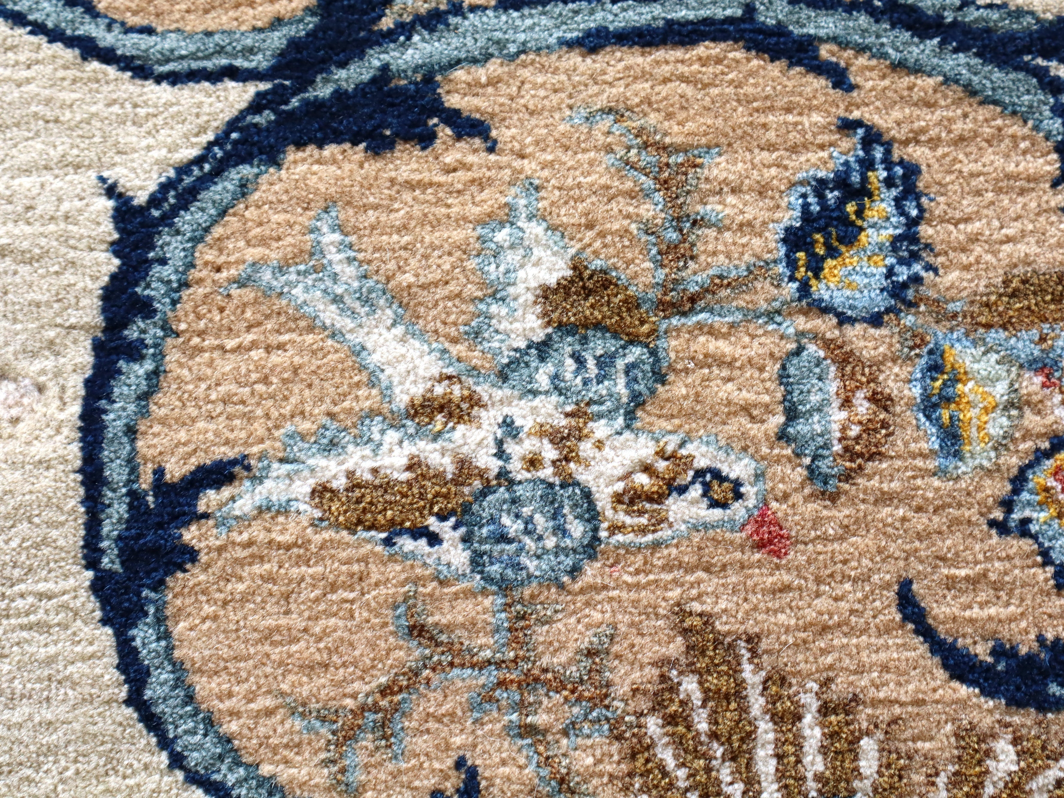 Persian Kashan rug close-up of tan and blue floral pattern with textured pile