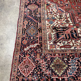Persian Heriz rug edge with red border stripe, navy motifs, cream accents, and short fringe.