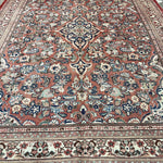 Persian Mahal rug with central medallion and scrolling floral patterns on rose background