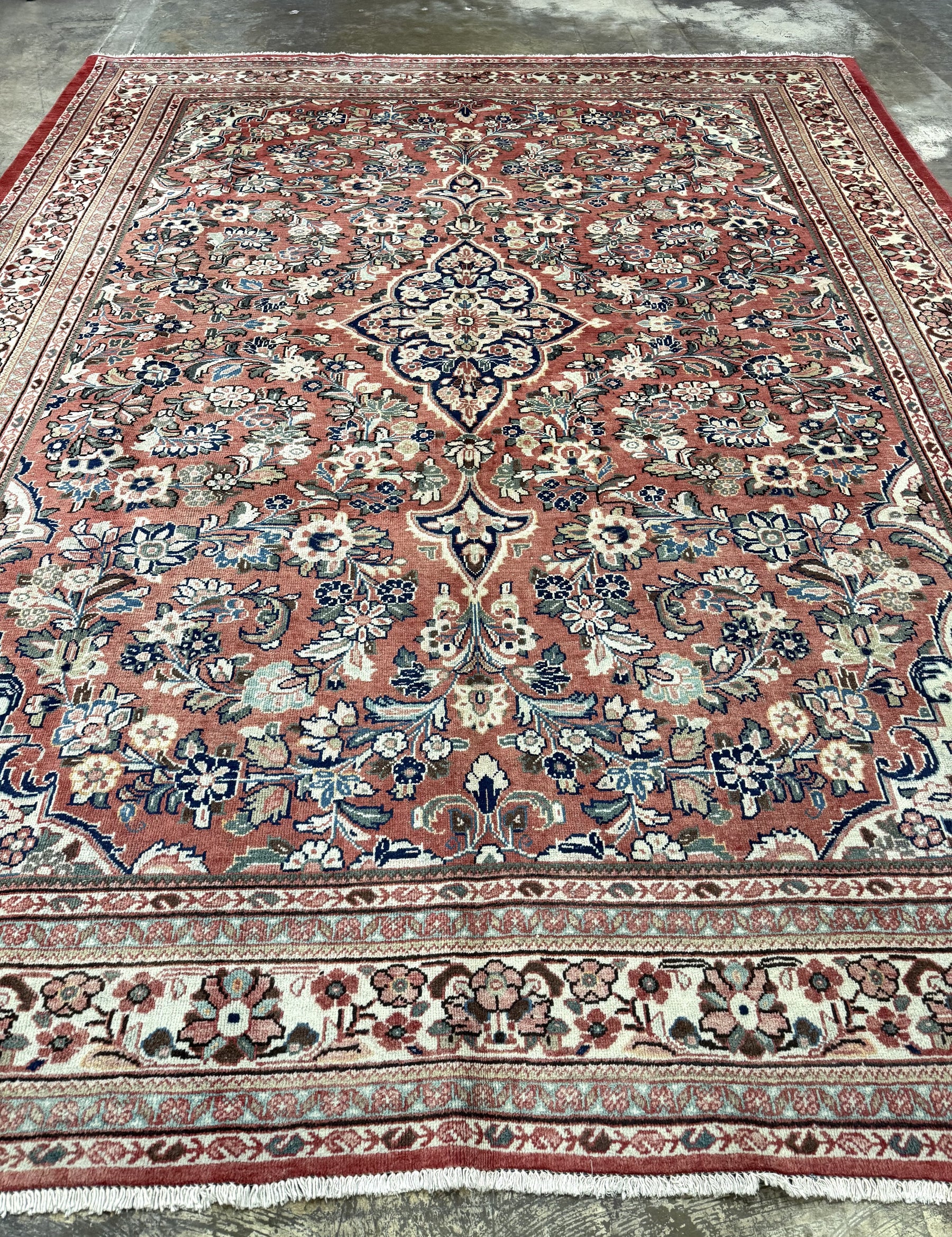 Persian Mahal rug with central medallion and scrolling floral patterns on rose background