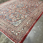 Persian Mahal rug, angled view, red edge trim with detailed blue and beige motifs