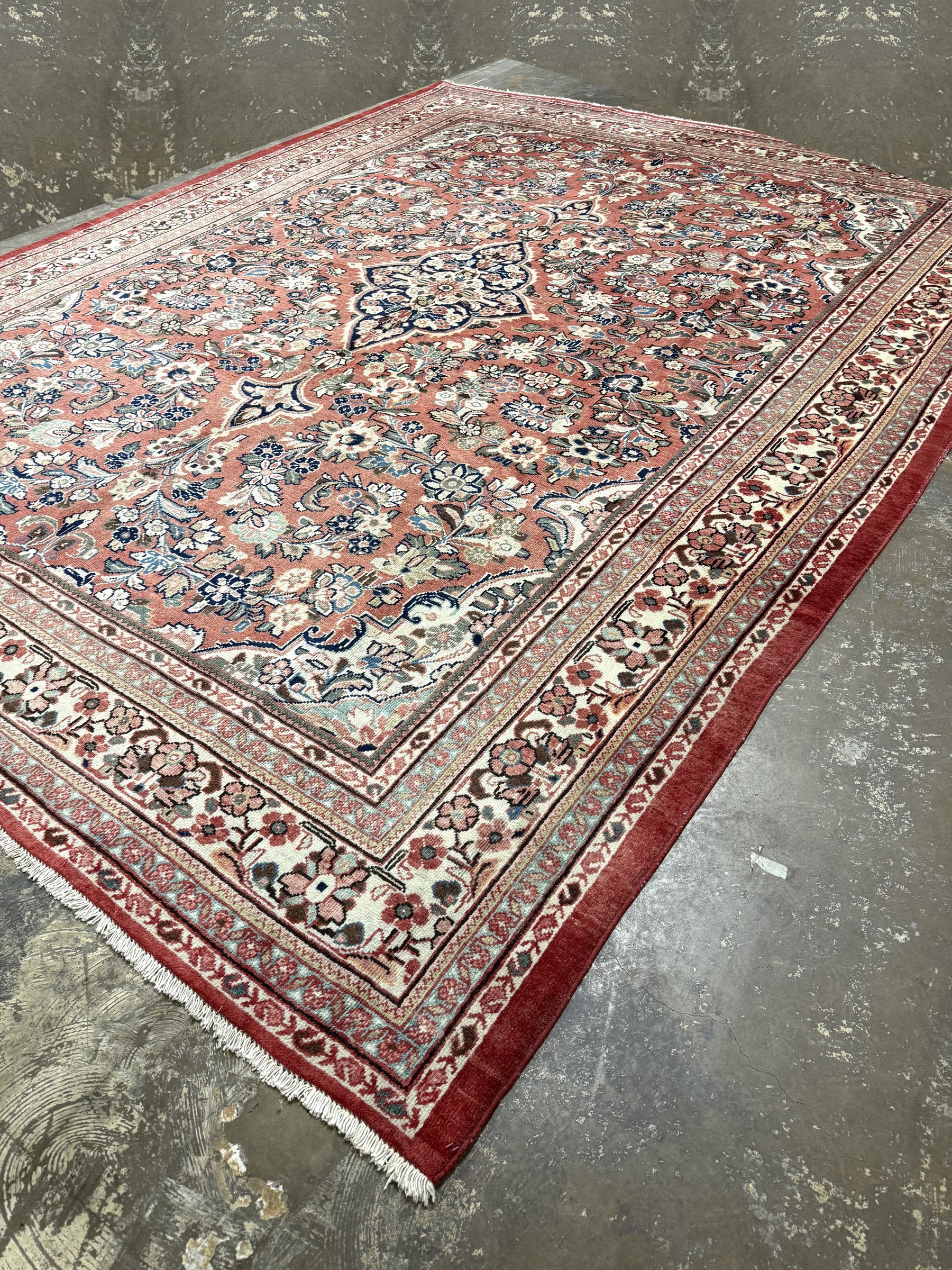 Persian Mahal rug, angled view, red edge trim with detailed blue and beige motifs