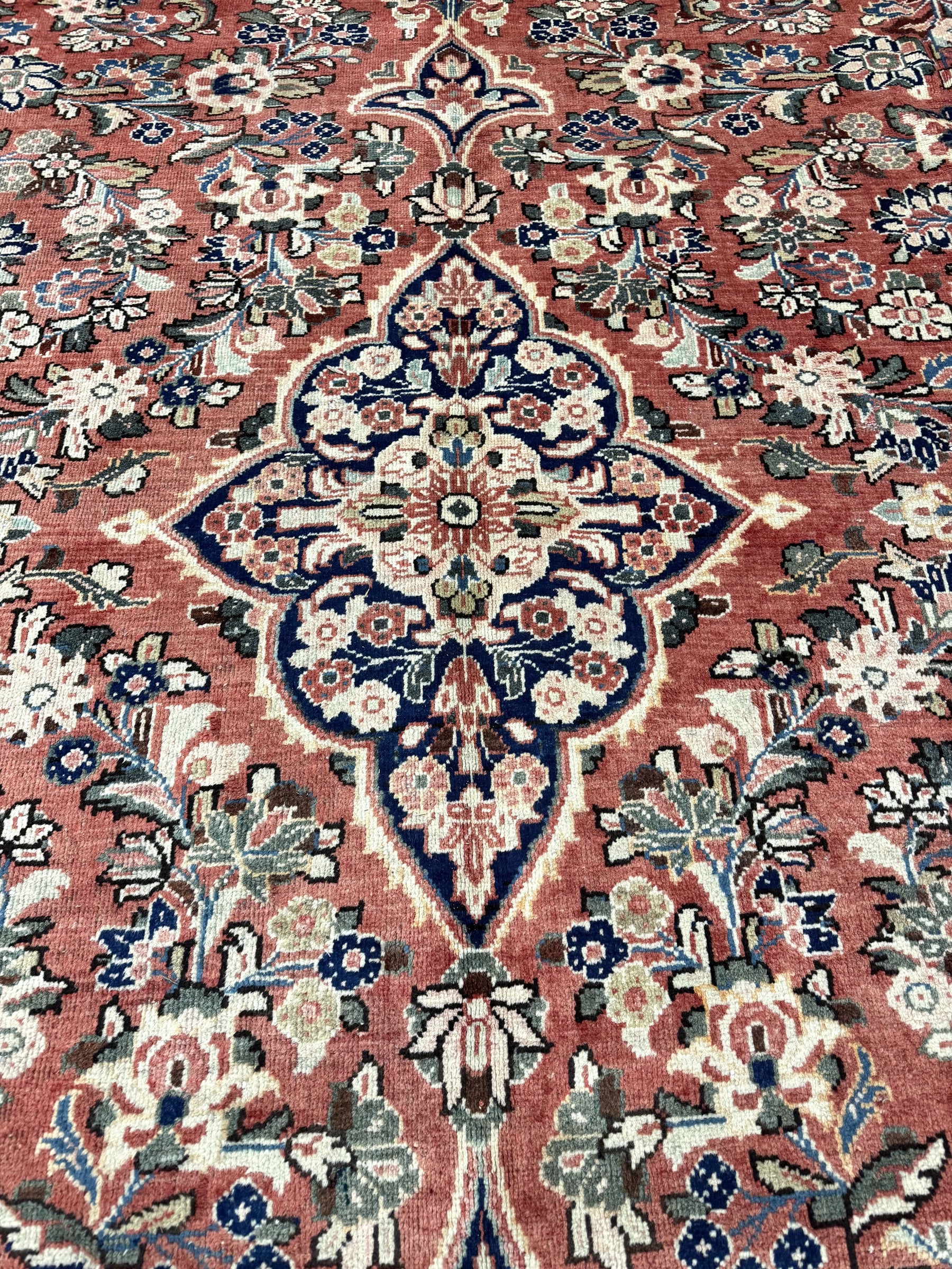 Persian Mahal rug close-up of navy medallion with red and cream floral accents