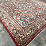 Persian Mahal rug, full view angled, rose field with ornate blue medallion and border