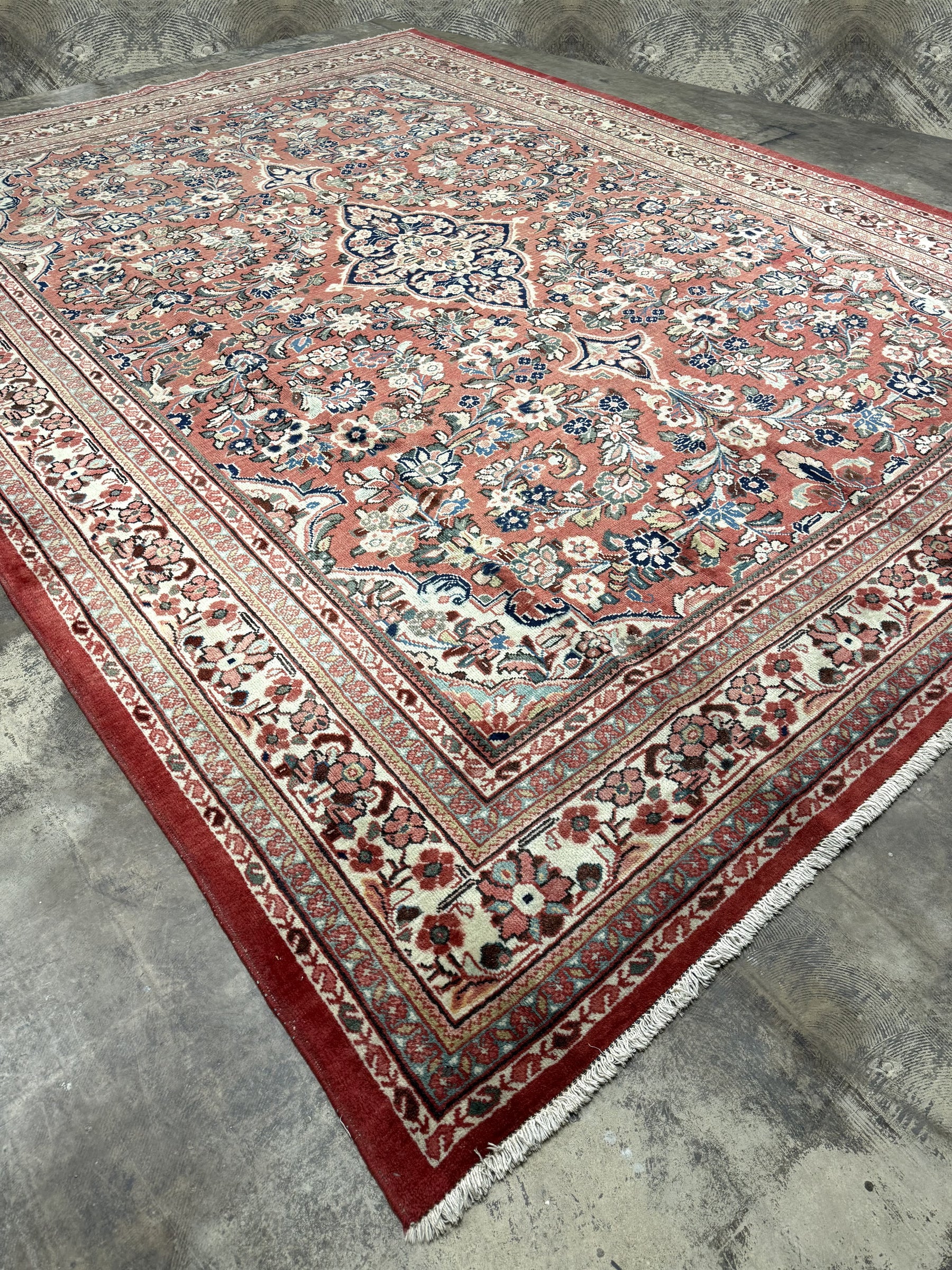 Persian Mahal rug, full view angled, rose field with ornate blue medallion and border