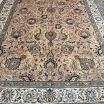 Persian Tabriz rug with central medallion, dusty beige tones and dark blue edging