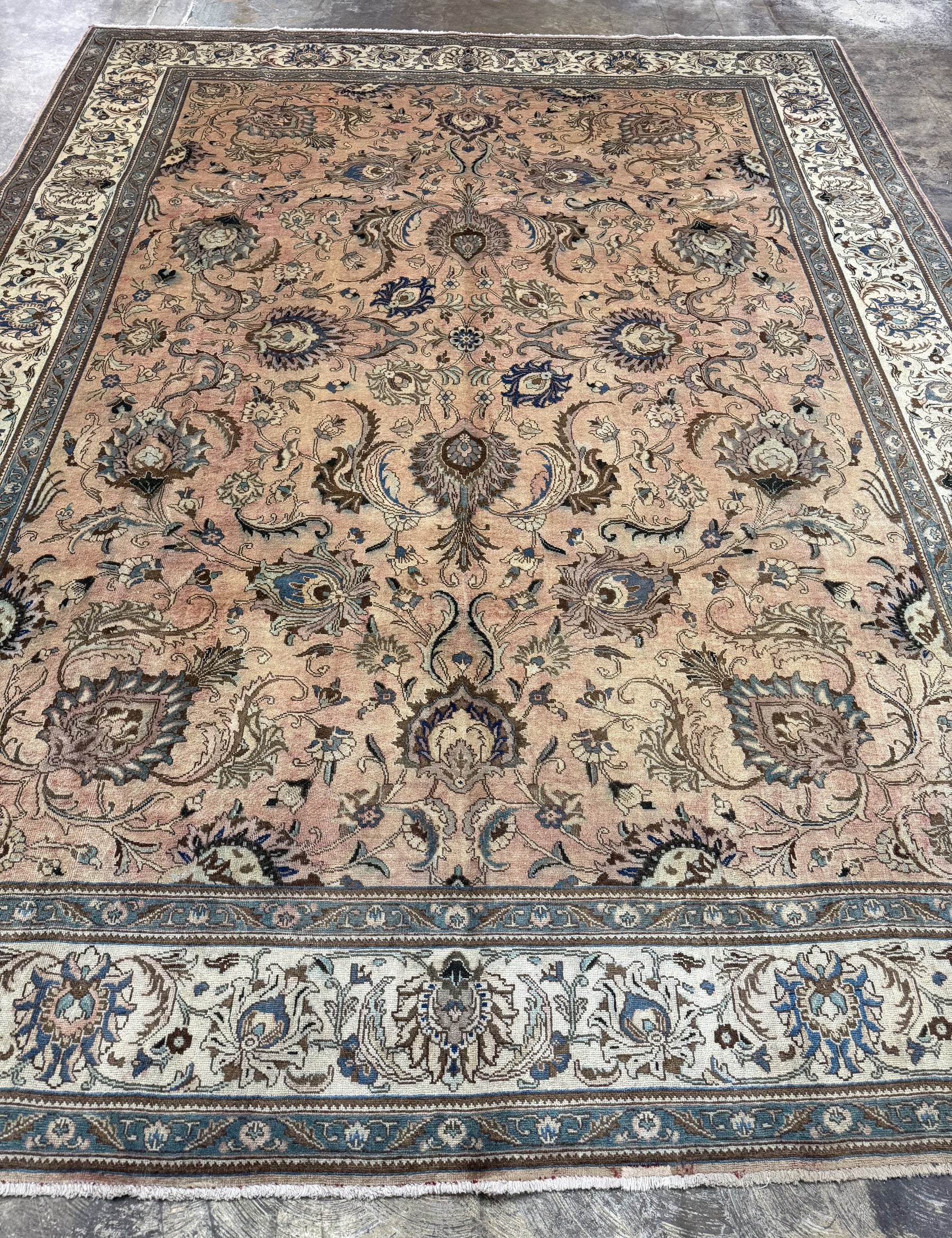 Persian Tabriz rug with central medallion, dusty beige tones and dark blue edging