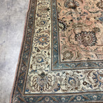 Persian Tabriz rug corner detail, teal and ivory scroll border on beige ground