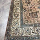 Persian Tabriz rug corner detail, teal and ivory scroll border on beige ground
