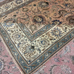 Persian Tabriz rug edge detail, pinkish-beige field with teal and cream ornamentation