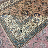 Persian Tabriz rug edge detail, pinkish-beige field with teal and cream ornamentation