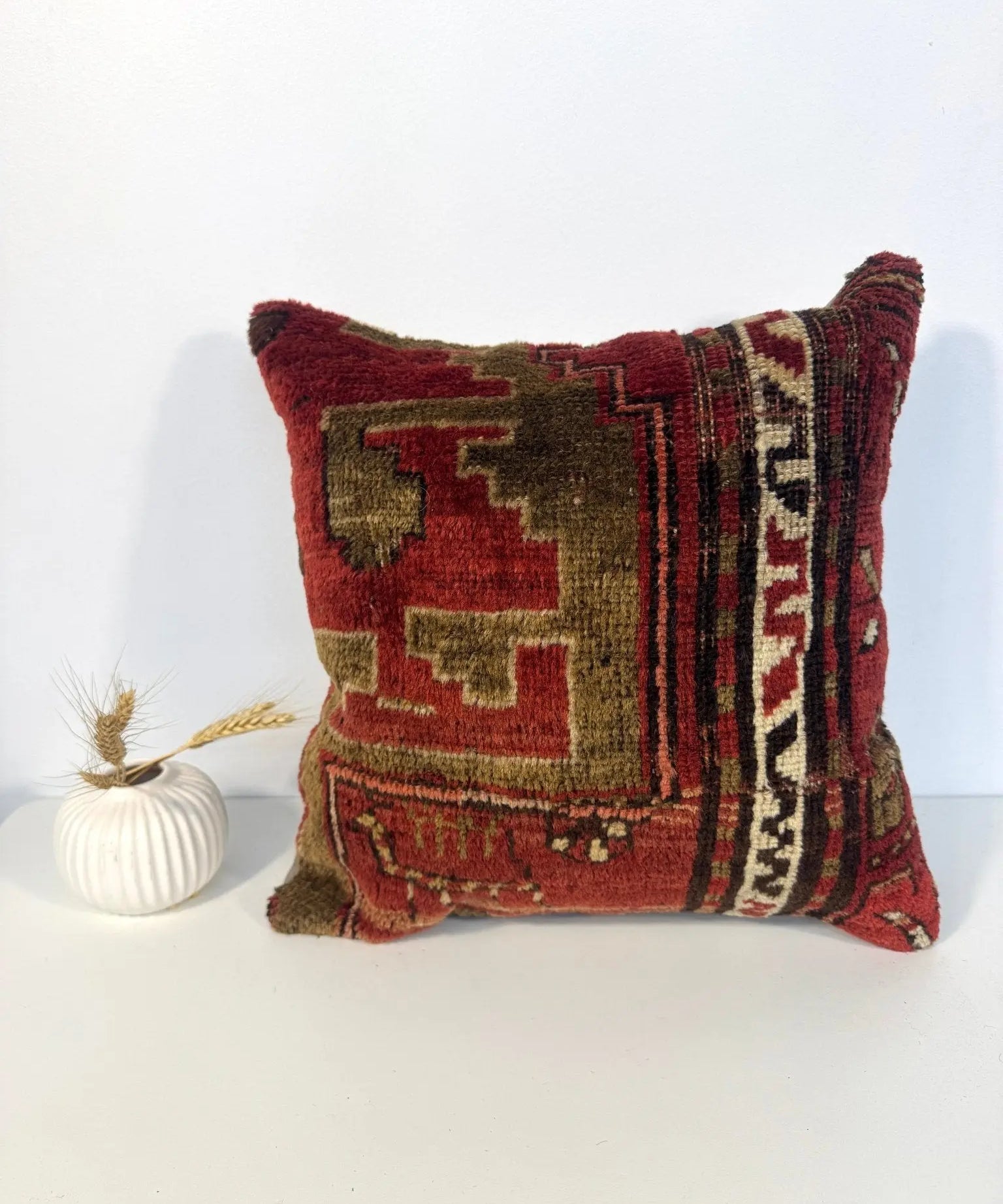 Woven square pillow cover, deep red with olive and cream geometric design, short fringe