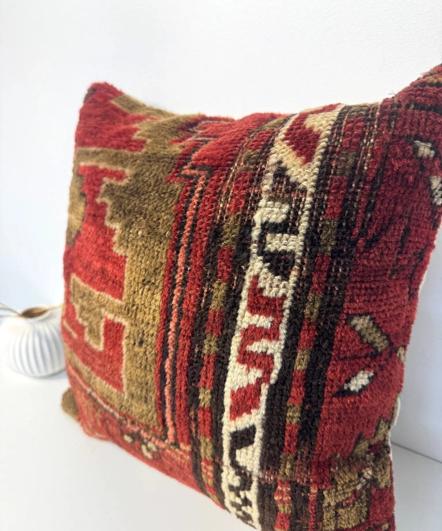 Woven pillow cover with red, olive, and cream geometric blocks and stripes