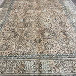 Tabriz-style rug with cream center and intricate blue floral corner motifs.