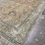 Tabriz-style rug, cream field with blue border and floral medallion patterns.