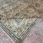 Tabriz-style rug with cream field, teal-blue border, and pink underlayer visible at edge.