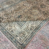 Tabriz-style rug with cream field, teal-blue border, and pink underlayer visible at edge.