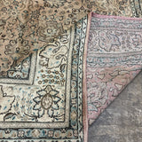 Tabriz-style rug corner detail with teal-blue border lines and patterned cream field.