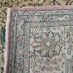 Tabriz-style rug border close-up with pink edge trim and floral medallion details.