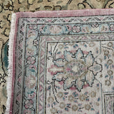 Tabriz-style rug border close-up with pink edge trim and floral medallion details.